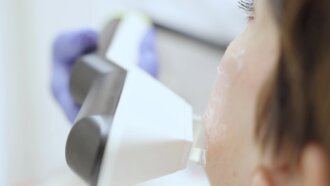 Chirurgien en train de réaliser un soin au laser sur une patiente